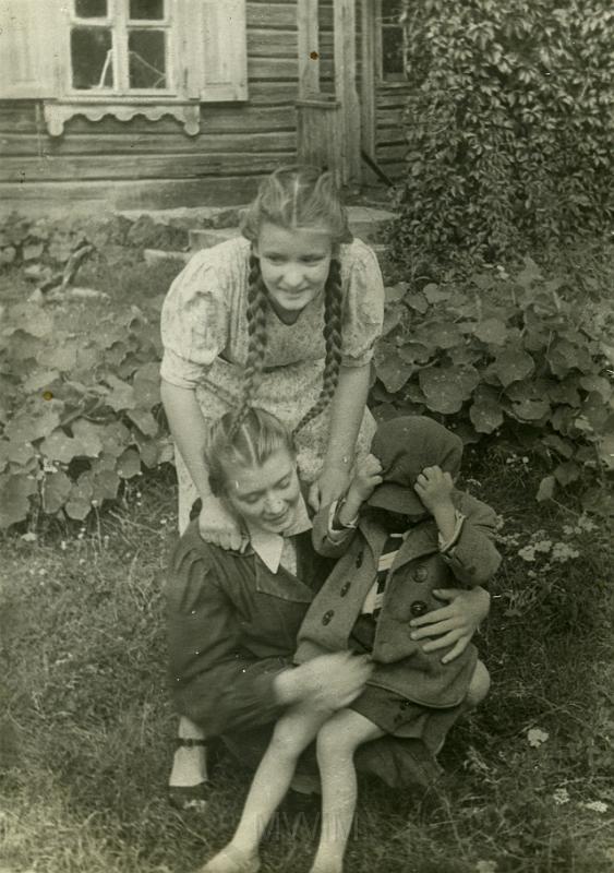 KKE 5125.jpg - Fot. Przed domem. Od lewej stoi: pierwsza Jagoda Mikołajewska, kuca jej siostra Halina Mikołajewska (obie w AK w czasie wojny), zakryty chłopczyk Andrzej Małyszko – syn Jana Małyszko, Taboryszki, 1944 r.